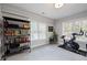 Bonus room features a bookshelf, two windows with blinds, neutral paint, and an exercise bike for convenient workouts at 1089 Greenleaf Se Rd, Atlanta, GA 30316