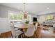 Bright dining room featuring a round wooden table, modern chandelier, and large windows with natural light at 1089 Greenleaf Se Rd, Atlanta, GA 30316