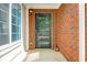 Close-up of a brick home's front entry showing the black trimmed front door and sidelight windows at 1535 Duluth Hwy # 1104, Lawrenceville, GA 30043