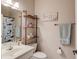 This quaint bathroom features a sink, toilet, mirror, and stylish wooden shelving at 657 Swans Landing Dr, Dacula, GA 30019