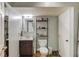 Bathroom with a dark wood vanity, toilet, shelving, and a full-length mirror at 657 Swans Landing Dr, Dacula, GA 30019