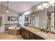 Bathroom featuring a soaking tub, double vanity, and pendant lights at 657 Swans Landing Dr, Dacula, GA 30019