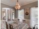 This dining room features a chandelier, a dining table, and sheer curtains on the windows at 657 Swans Landing Dr, Dacula, GA 30019