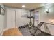 Bright home gym with wood floors, a weight bench, pull up station, wall sconces, and bright windows at 657 Swans Landing Dr, Dacula, GA 30019