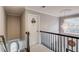 Carpeted hallway featuring a chandelier, window, and stairwell at 657 Swans Landing Dr, Dacula, GA 30019