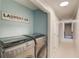A well-lit laundry room features a washer and dryer, as well as storage space at 657 Swans Landing Dr, Dacula, GA 30019