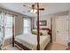 This bedroom features natural light from two windows and a wooden four-poster bed at 657 Swans Landing Dr, Dacula, GA 30019