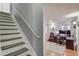 A well-lit room with a staircase, and an open layout featuring an office space with built-in cabinets and work space at 657 Swans Landing Dr, Dacula, GA 30019