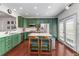 Bright, modern kitchen with green cabinetry, stainless steel appliances, a center island, and double doors to the exterior at 1012 E Paces Chase, Atlanta, GA 30326