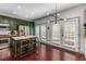 Stylish kitchen with stainless steel appliances, an island with bar stools, custom green cabinets, and ample light at 1012 E Paces Chase, Atlanta, GA 30326