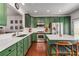 Stylish kitchen featuring green cabinetry, stainless steel appliances, white countertops, and an island with seating at 1012 E Paces Chase, Atlanta, GA 30326
