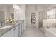 Bathroom featuring dual sinks, granite countertops, walk-in shower, and separate tub at 1054 Georgian Point Dr, Lawrenceville, GA 30045