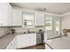 Beautiful kitchen featuring white cabinets, stainless steel appliances, tile backsplash, and hardwood floors at 1054 Georgian Point Dr, Lawrenceville, GA 30045