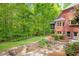 Lush backyard features a brick home, screened porch, and a meticulously landscaped stone pathway at 221 Streamside Ct, Lilburn, GA 30047