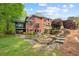 Brick home featuring a charming screened porch, stone patio, and lush landscaping in the backyard at 221 Streamside Ct, Lilburn, GA 30047