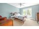 Light-filled bedroom featuring soft blue walls, plush carpet, and a ceiling fan for added comfort at 221 Streamside Ct, Lilburn, GA 30047