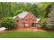 Elegant two-story red brick home with a well-manicured lawn and lush, mature landscaping at 221 Streamside Ct, Lilburn, GA 30047