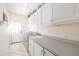 Functional laundry room with white cabinets, a sink, and modern appliances at 221 Streamside Ct, Lilburn, GA 30047