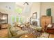 Comfortable living room with fireplace, high ceilings and ample natural light from the French doors at 221 Streamside Ct, Lilburn, GA 30047