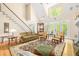 Bright living room with large windows, a fireplace, and an adjacent staircase at 221 Streamside Ct, Lilburn, GA 30047