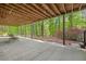 Covered patio with concrete floor overlooking lush greenery, perfect for outdoor seating and relaxation at 221 Streamside Ct, Lilburn, GA 30047