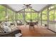 Inviting screened porch featuring wood flooring, ample seating, and serene views of the surrounding greenery at 221 Streamside Ct, Lilburn, GA 30047