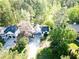 Aerial view of a two-story home with a long driveway, surrounded by lush greenery and neighboring houses at 3088 Mount Tabor Church Rd, Dallas, GA 30157