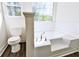Bright bathroom with a garden tub, toilet, and wood-look flooring at 3088 Mount Tabor Church Rd, Dallas, GA 30157
