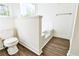 Bathroom featuring a toilet, tub, and wood-look flooring at 3088 Mount Tabor Church Rd, Dallas, GA 30157