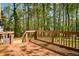 Spacious wooden deck with railing, providing an outdoor living space surrounded by tall trees at 3088 Mount Tabor Church Rd, Dallas, GA 30157
