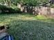View of the backyard featuring overgrown grass and a wooden fence at 520 Pine Dr, Pine Lake, GA 30072