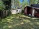 Large backyard with lush green grass and partial view of the cozy cabin at 520 Pine Dr, Pine Lake, GA 30072