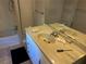An outdated bathroom featuring a single sink vanity, a large mirror, and a bathtub with tiled walls at 520 Pine Dr, Pine Lake, GA 30072