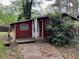 Exterior view of a red home featuring a small porch and front yard at 520 Pine Dr, Pine Lake, GA 30072