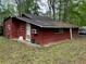 Cozy one-story cabin with red wood exterior and lush green surroundings at 520 Pine Dr, Pine Lake, GA 30072