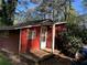 Charming home exterior featuring dark red siding, white trim, and natural light at 520 Pine Dr, Pine Lake, GA 30072