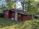 An exterior shot of a red home with white trim and a green yard at 520 Pine Dr, Pine Lake, GA 30072