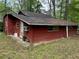 Cozy one-story cabin with red wood exterior and lush green surroundings at 520 Pine Dr, Pine Lake, GA 30072