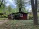 Cozy one story red house with a lush, green front yard and natural surroundings at 520 Pine Dr, Pine Lake, GA 30072