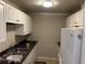 Functional kitchen with white cabinets, black countertop and stainless steel sink at 520 Pine Dr, Pine Lake, GA 30072