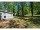 A view of the flat backyard area, surrounded by mature trees, offers privacy and space at 5844 Earlwane Dr, Lithonia, GA 30058
