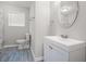 Bathroom features a white vanity, round mirror and a walk-in shower at 5844 Earlwane Dr, Lithonia, GA 30058