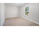 Bedroom features light gray walls, neutral carpet, and a bright window at 5844 Earlwane Dr, Lithonia, GA 30058