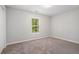 Cozy bedroom with neutral carpet, a window with a view, and fresh, light paint at 5844 Earlwane Dr, Lithonia, GA 30058