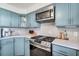 The kitchen showcases stainless steel appliances, stone countertops, and blue cabinetry at 777 Forrest Nw St, Atlanta, GA 30318