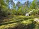 Expansive backyard with lush green grass, trees, and a storage shed at 175 Stoneview Cir, Covington, GA 30016