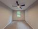 Bright bedroom with plush carpet, ceiling fan, and natural light through the window at 175 Stoneview Cir, Covington, GA 30016