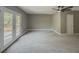 Open living space with neutral walls, carpet, door to outside, and modern fan at 175 Stoneview Cir, Covington, GA 30016