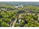 Aerial view of a neighborhood, showcasing the home's location near a lake and surrounded by lush greenery at 2265 Pemberton Pt, Buford, GA 30519