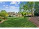 Spacious backyard with lush green lawn and view of the home's rear exterior at 2265 Pemberton Pt, Buford, GA 30519